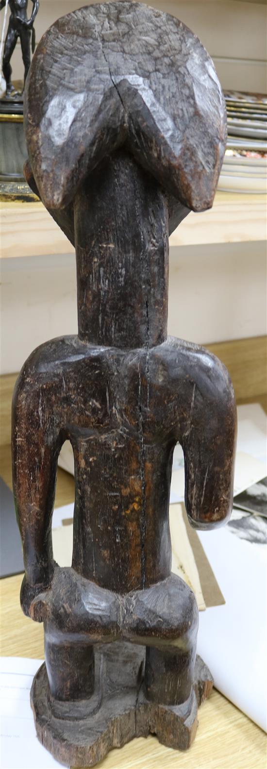 A West African carved wood figure of a standing man height 64cm